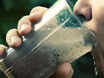 Man drinking a dirty glass of water